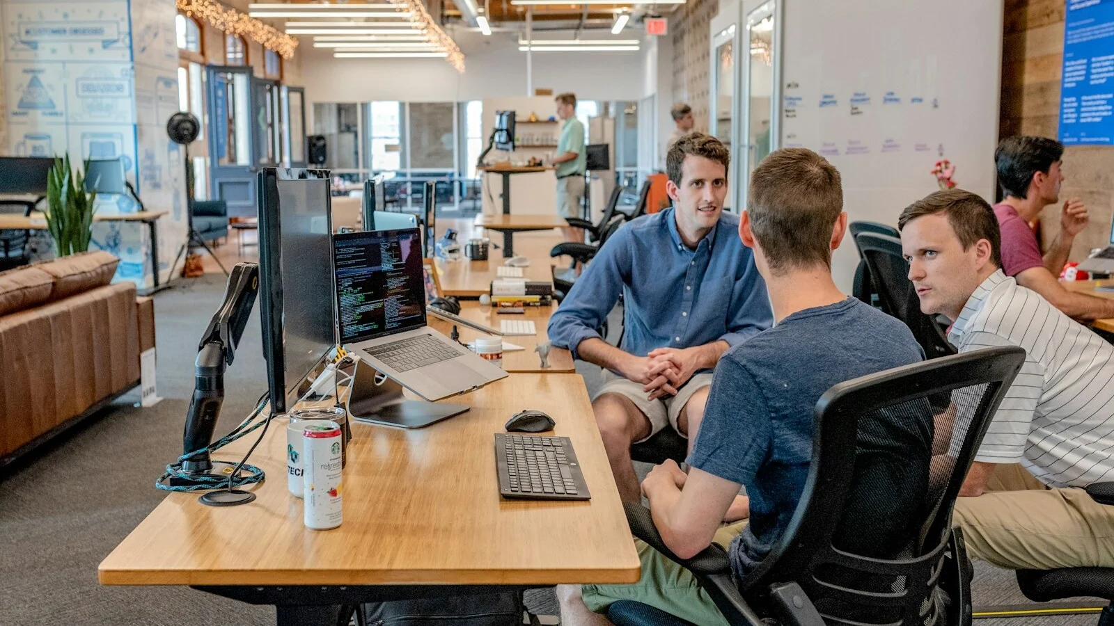 Two business professionals exchange a greeting and business cards in a modern office.