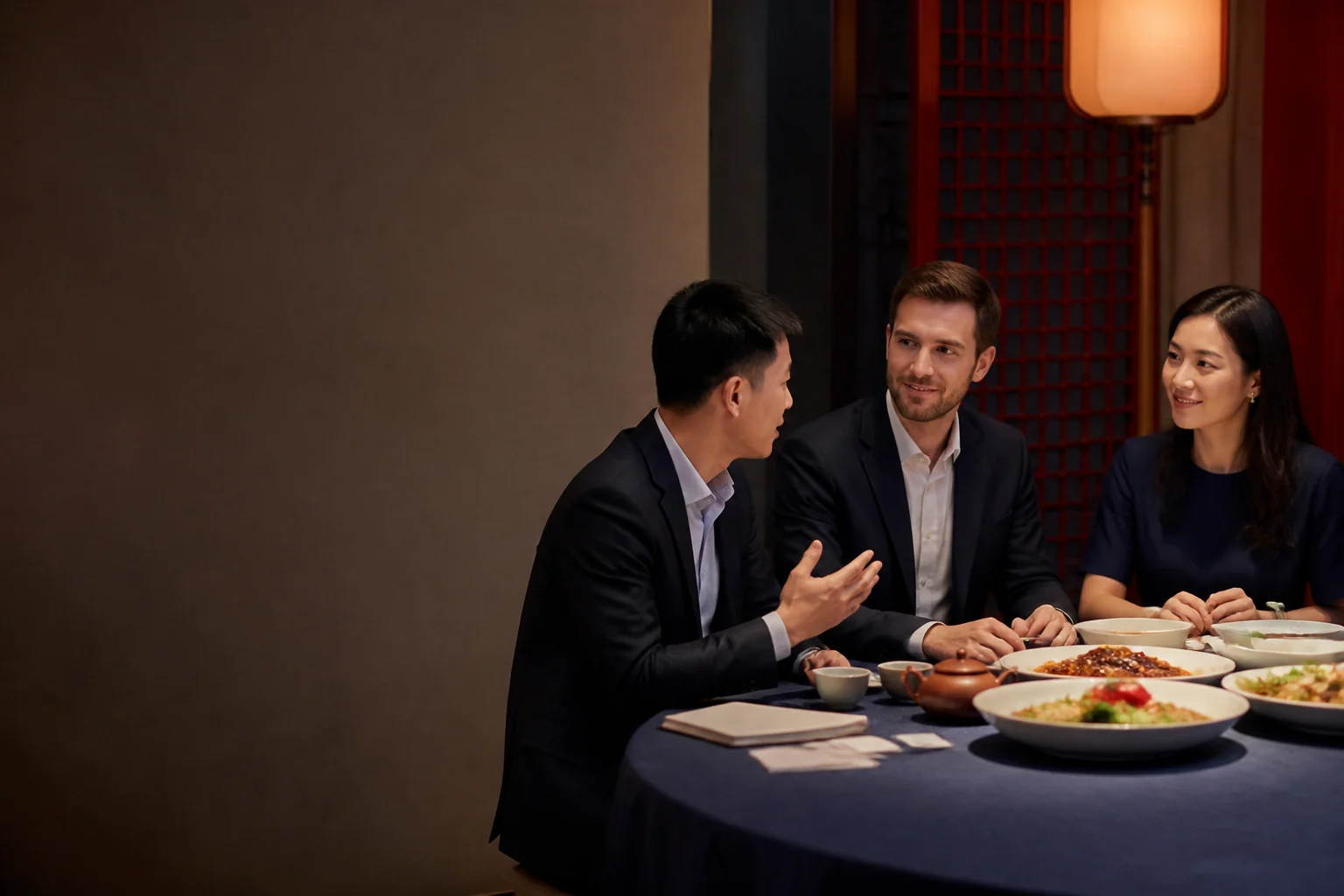 Business professionals making small talk before a meeting at a Chinese business dinner.
